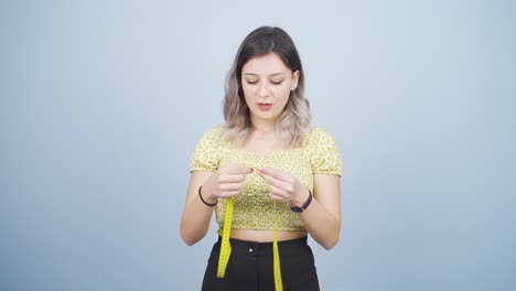 unhappy person measuring her weight with a tape measure.