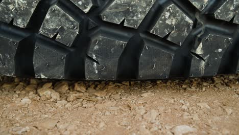 a dolly macro shot of a tire laying on gravel on the ground.