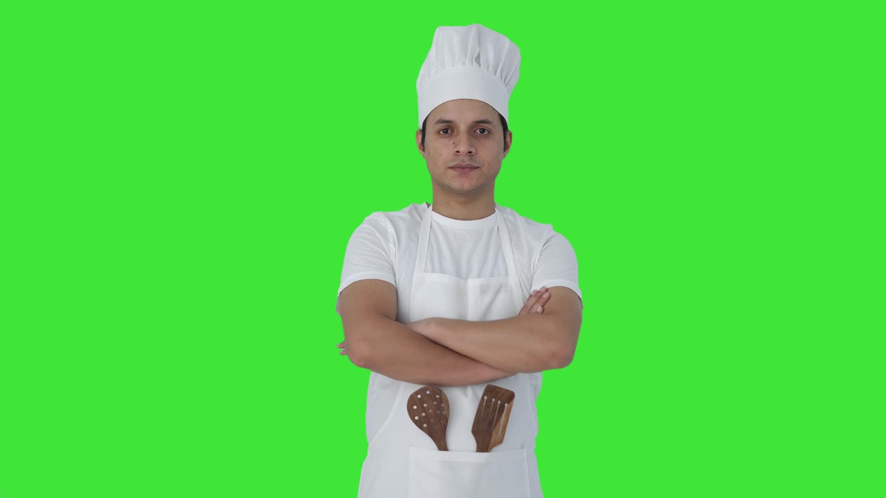 Ritratto di chef professionista indiano fiducioso su green screen