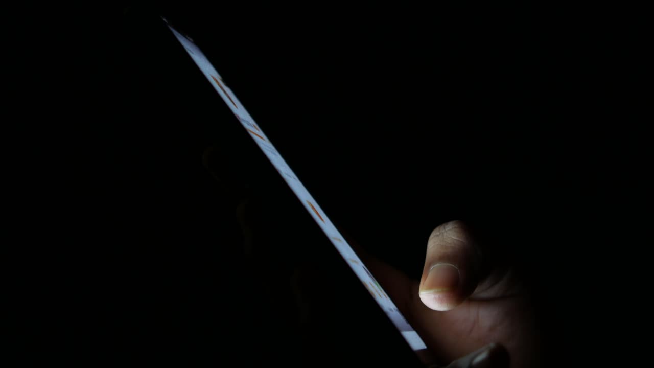 persona que utiliza un teléfono inteligente por la noche