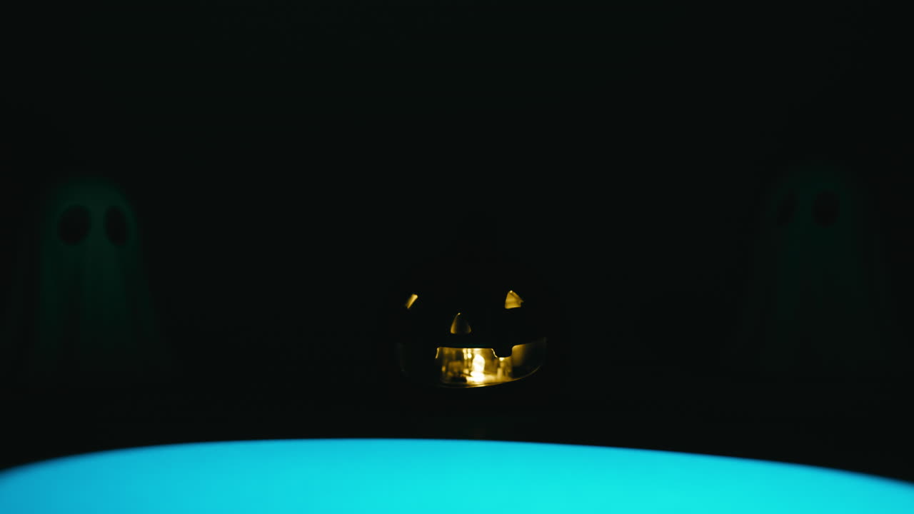 Light beam searches for ghosts and Halloween pumpkin at scary night