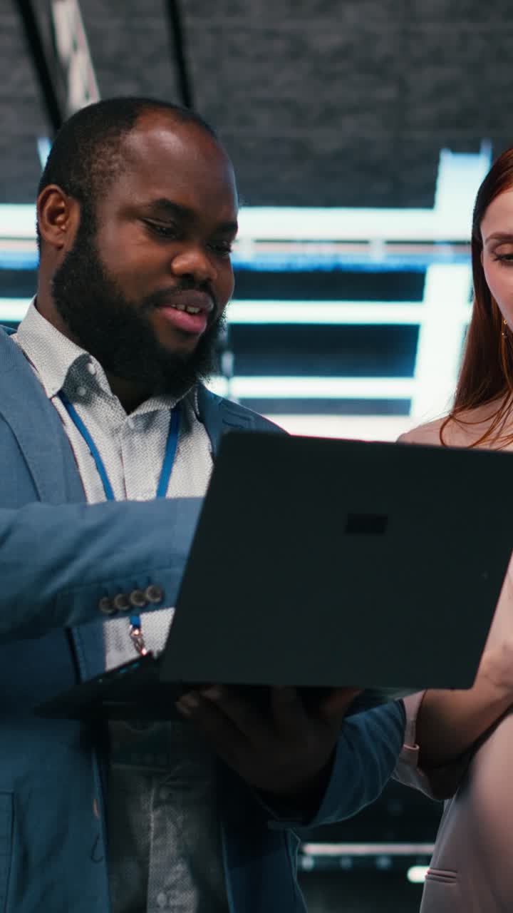 Video verticale: Colleghi che collaborano nella sala server usando tablet e laptop