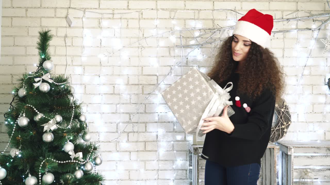 New Year presents concept. Woman opening her New Year gift boxes while lying at home