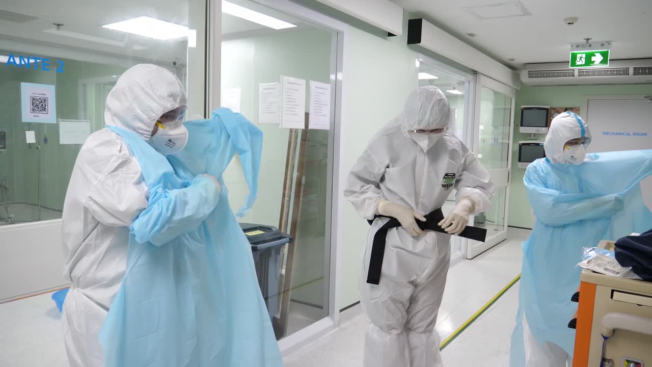 personal médico poniéndose trajes de papr antes de ingresar a la sala covd-19