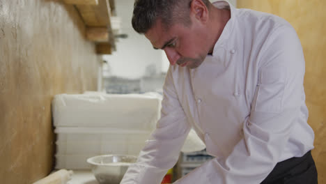 caucasian man making a pizza dough