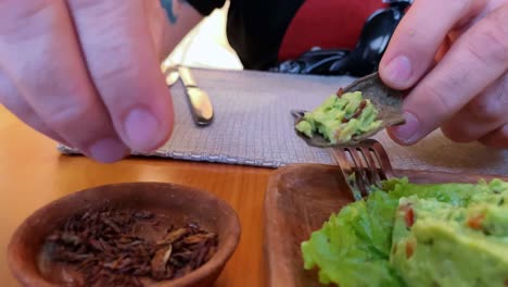 closeup shot caucasian man eating chapulines grasshoppers restaurant in mexico