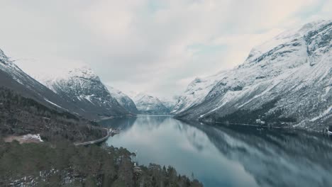 crystal clear mountain lake surrounded by snowy peaks in norway, loen, aerial view