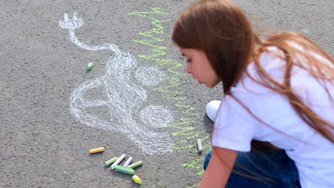 little girl with creative craft hobby drawing electro on the asphalt with chalk car environment, eco friendly, save energy in park at summer day