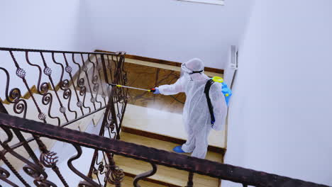 biologist in full hazmat suit sprays disinfectant