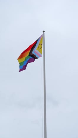 pride flag in motion against overcast gray sky