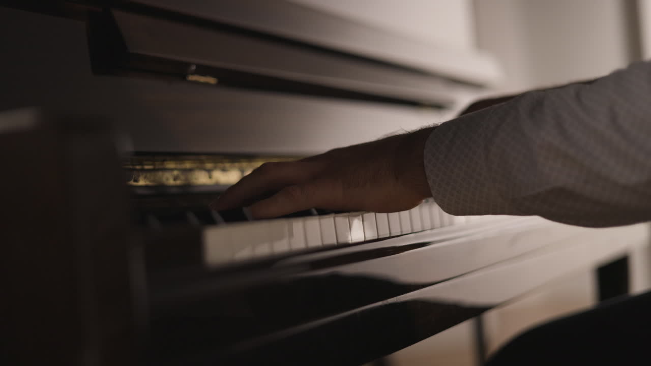 manos de un pianista masculino irreconocible tocando piano vertical, de cerca