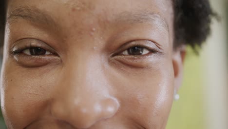 retrato de cerca de los ojos de una feliz mujer de negocios afroamericana en la oficina, en cámara lenta