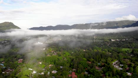 nubes bajas sobre casas en la ciudad de valle de anton en el centro de panamá cráter del volcán extinto, tiro aéreo a la derecha