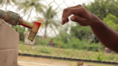 concept of water conservation, turning of leaking public water tank water from the tap