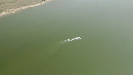 aerial view of speedboat pulling inner tubers at saskatchewan landing, canada