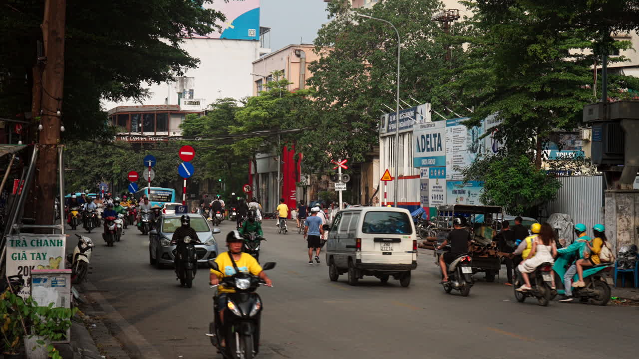 Electric two wheelers and mopeds on Hanoi Street, Urban city street traffic, Handheld shot