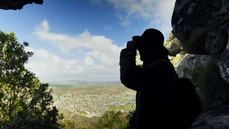 excursionista masculino mirando a través de binoculares en el campo 4k