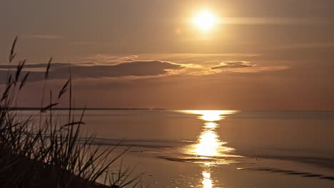 timelapse słońca zachodzącego nad oceanem na horyzoncie z chmurami przechodzącymi wieczorem