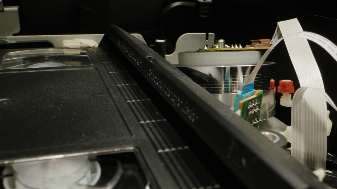 Old video recorder inside close-up, VHS. Retro player in neon blue light, vintage video cassette broadcasting, audio tape.