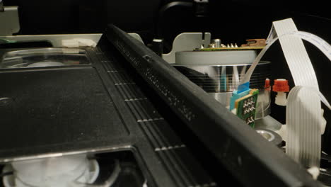 old video recorder inside close-up, vhs. retro player in neon blue light, vintage video cassette broadcasting, audio tape.