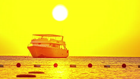 timelapse of sunrise above a yacht moored at an anchor moving in the sea