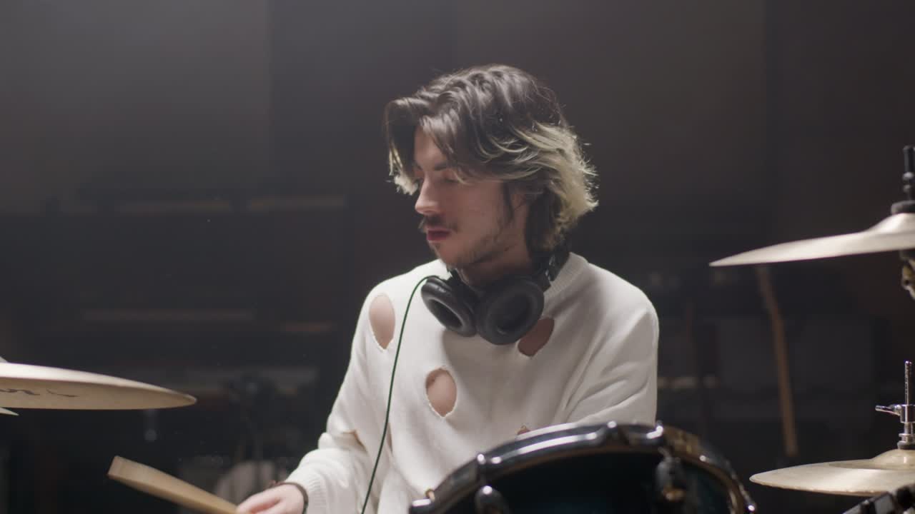 baterista con una camisa de moda tocando la batería en un estudio de música