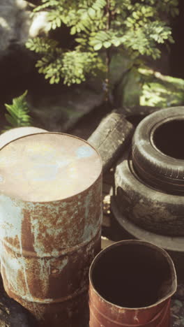 rusty barrel and stack of old tires in nature