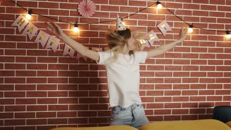 mujer con gorra de cumpleaños bailando y girando, feliz por su cumpleaños