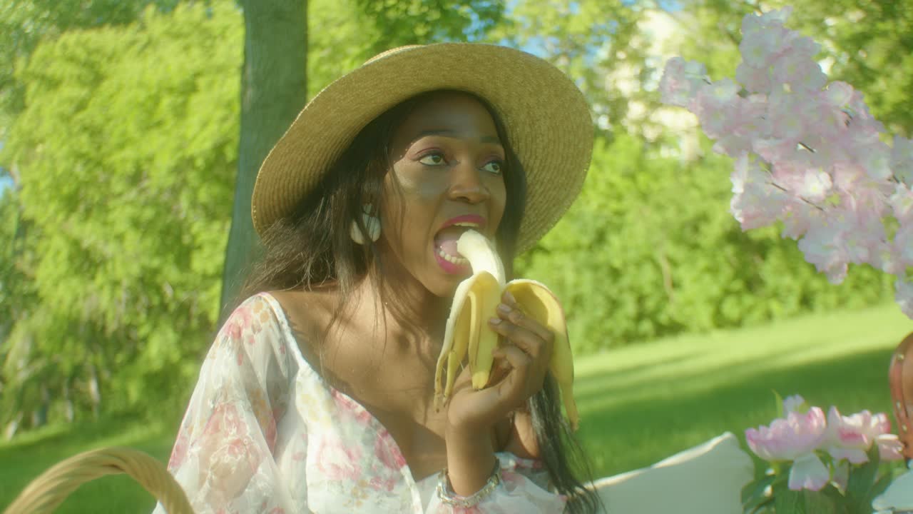 mujer negra comiendo plátano en el parque dolly en primer plano
