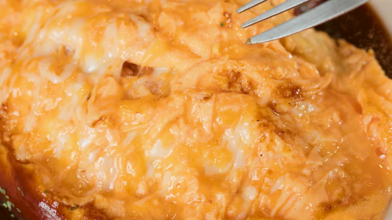 Close-up of fork lifting cheesy Japanese omelette rice, creamy sauce, warm lighting, shallow focus