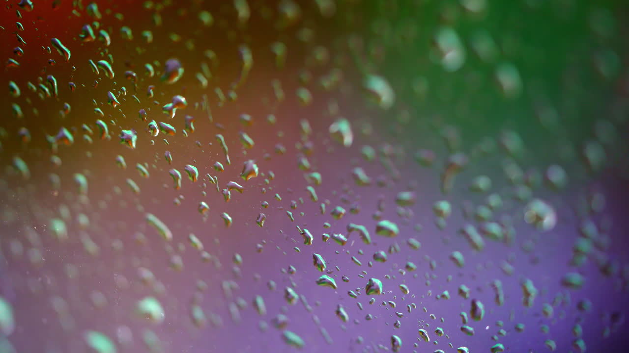 Colorful texture with water drops. Rain drops on window. Water droplets falling on glass in rainy weather. Close-up.