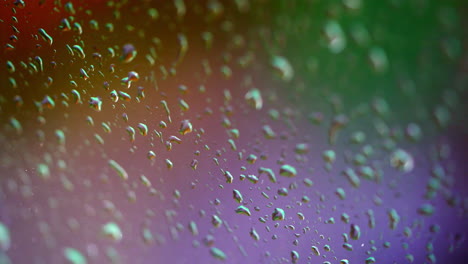 colorful texture with water drops. rain drops on window. water droplets falling on glass in rainy weather. close-up.
