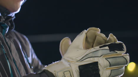 close-up of gloved hand clapping together with intricate stitching and reinforced padding captured during outdoor activity under soft light