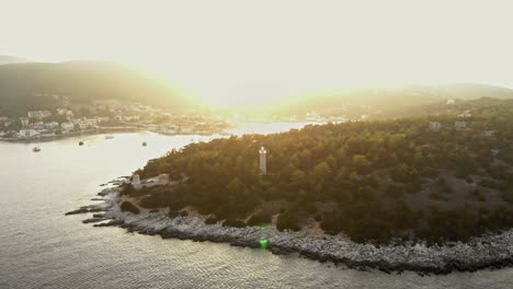 Vista-Aérea-Del-Faro-De-Fiskardo-Rodeado-De-Un-Exuberante-Bosque-Al-Atardecer-En-La-Isla-De-Kefalonia,-Grecia