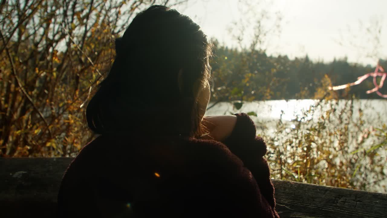 mujer mirando a un lago en cámara lenta de 4k