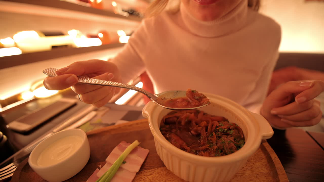 Woman eating meat soup at business lunch in a restaurant