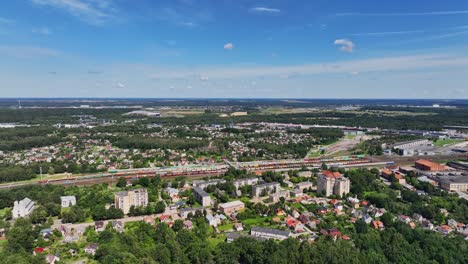 panoramic view, houses of a small town stand near the railway station, sunny summer day