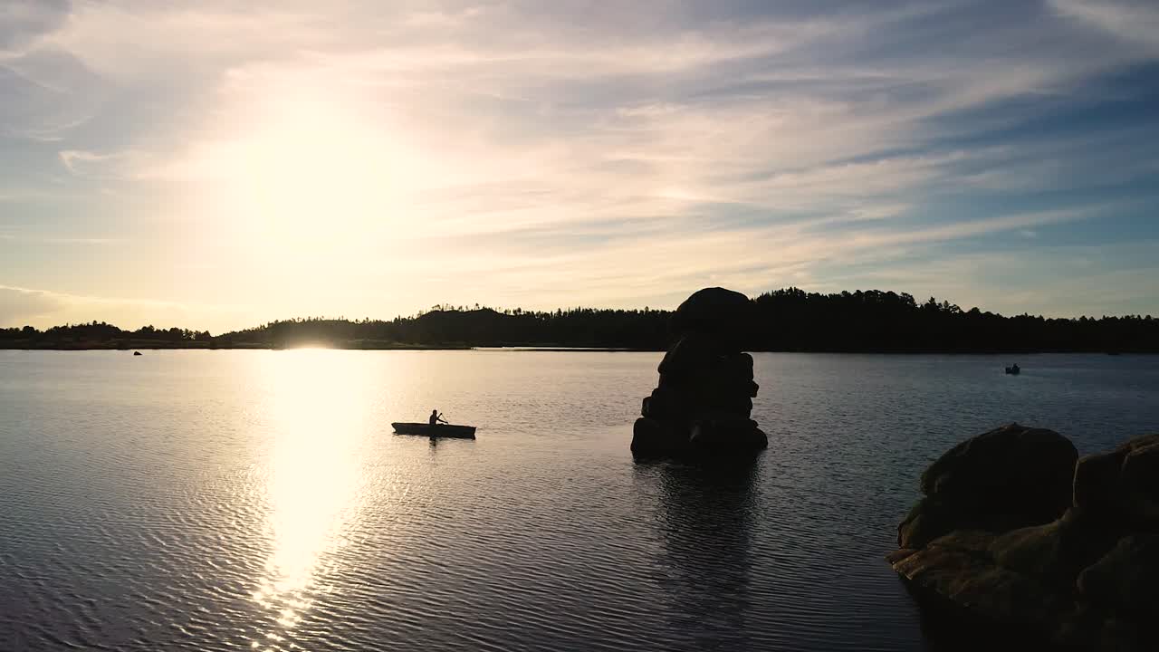 떠오르는 태양을 배경으로 카누의 실루엣이 있는 호수의 아름다운 콜로라도 일출