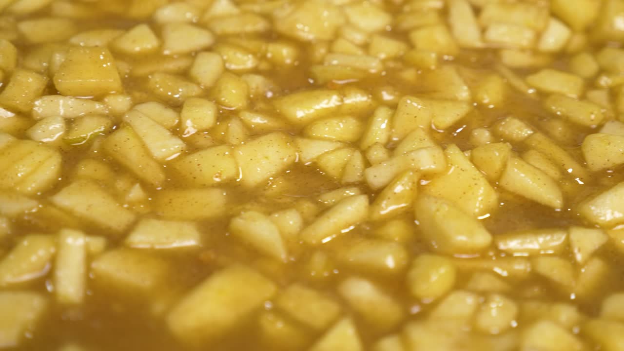 크럼블 파이 요리를 위해 얇게 썬 사과 조각을 베이킹 폼 안에 붓습니다.