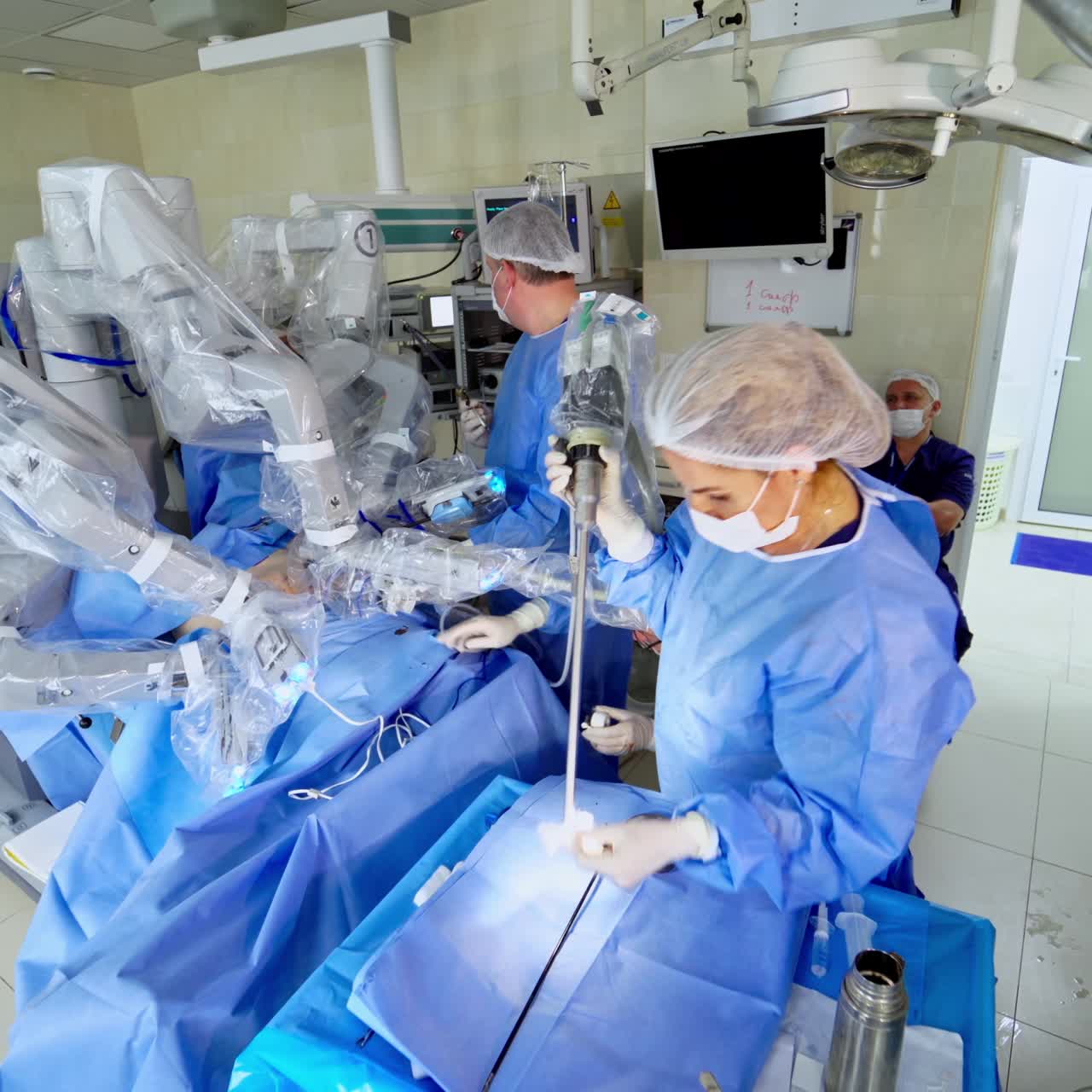 Team of doctors near the medical robot in clinic. Modern surgery with robotic equipment in the surgical room. Professional doctors perform a microsurgery