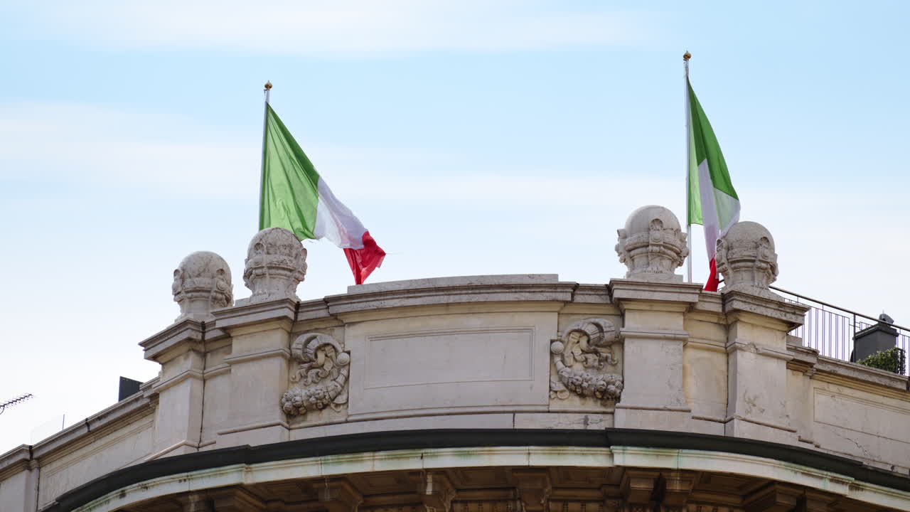 Primo piano di due bandiere italiane che sventolano al vento sulla cima di un edificio