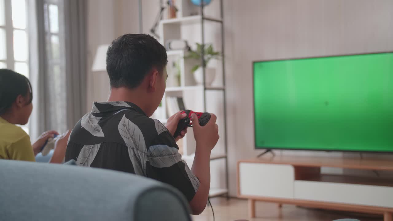 Bambini con joystick giocano a un videogioco su una TV con schermo verde