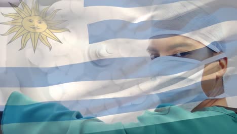 Animation-of-flag-of-uruguai-waving-over-surgeons-in-operating-theatre