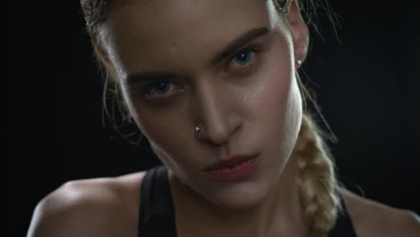 aggressive woman biting lips looking to camera on black background