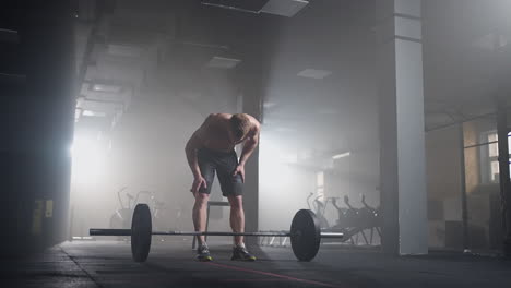 slow motion: male powerlifter preparing for training in gym. screaming man lifting weights