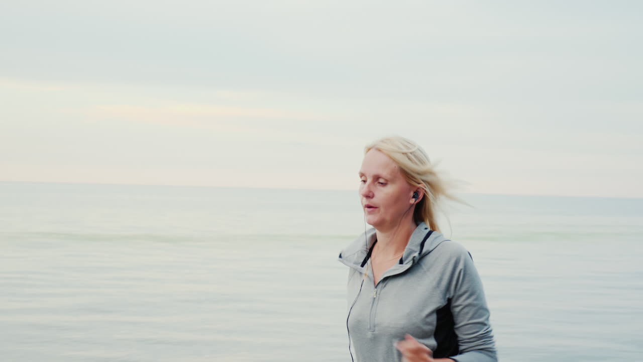 mujer trotando a lo largo de una orilla temprano en la mañana