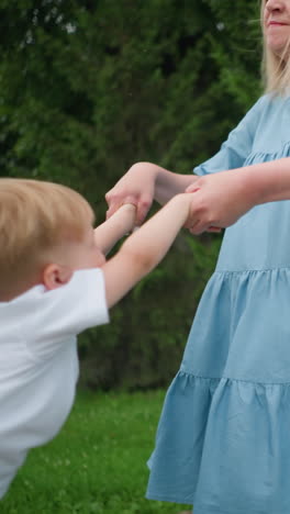una madre gira a su hijo juguetón mientras su vestido flota en el viento