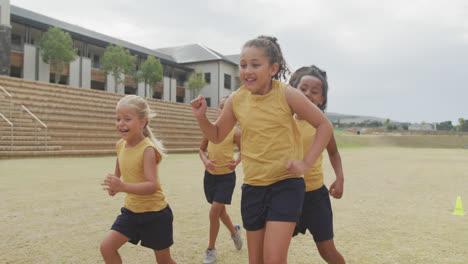 video of legs of diverse girls playing soccer in front of school