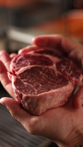 raw steak held in hands
