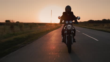 Die-Silhouette-Eines-Motorradfahrers,-Der-Bei-Sonnenuntergang-Die-Stadt-Verlässt-1